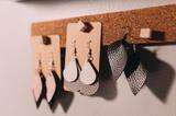 leather earrings in multiple shapes hanged on the wall
