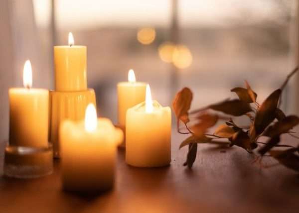 burnt-white-candles-in-a-wooden-table-with a flower on the side