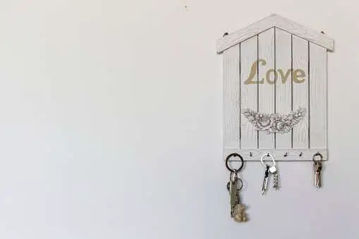 wooden modern key holder in white color and keys hanged from the hooks
