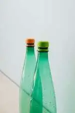 two empty green plastic bottles